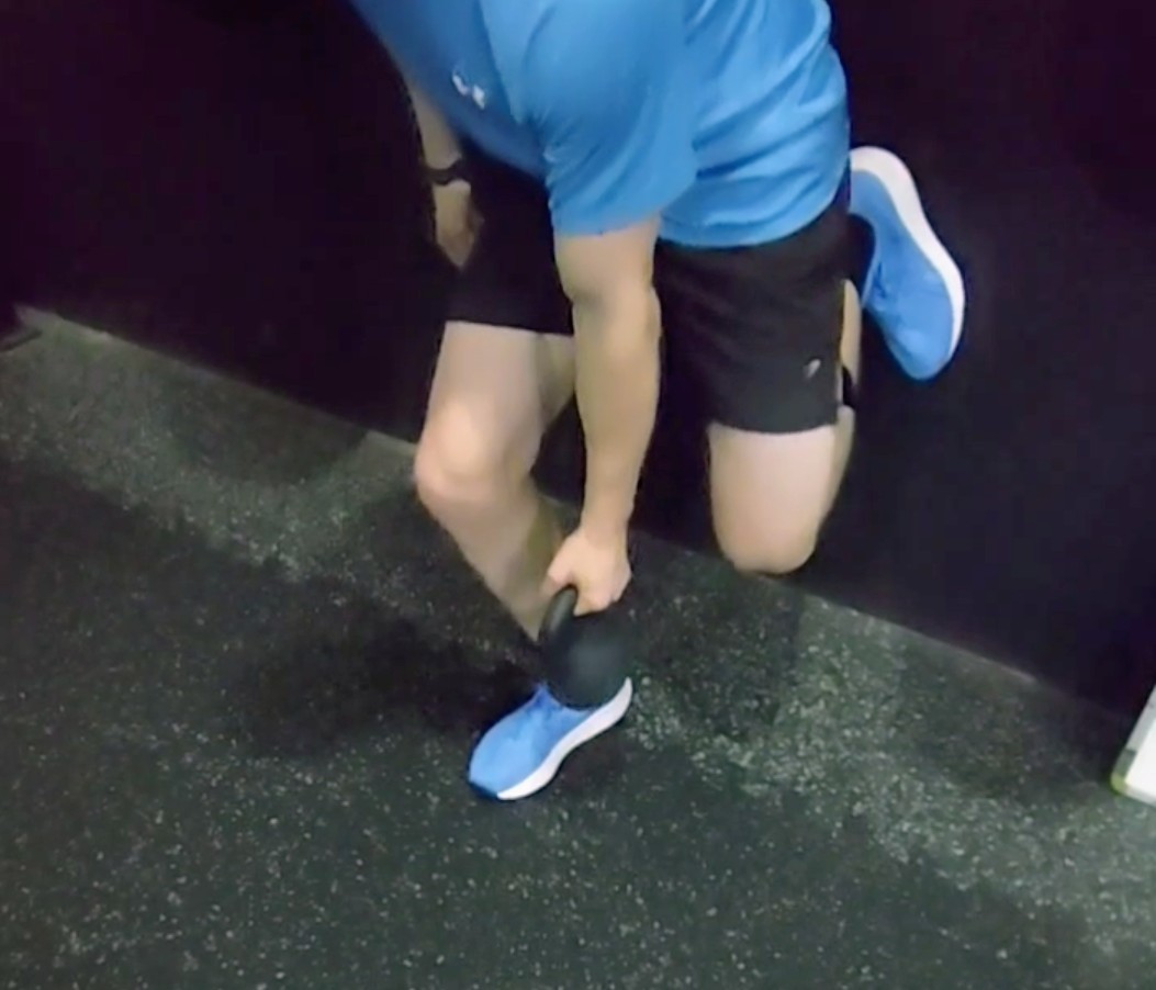 Sports rehabilitation strength training using kettlebell for lower limb stability Physiotherapy exercise targeting knee control balance and functional movement patterns Injury rehabilitation drill improving unilateral strength coordination and mobility Athlete conditioning exercise enhancing proprioception stability and musculoskeletal performance Strength and conditioning training supporting recovery injury prevention and movement efficiency